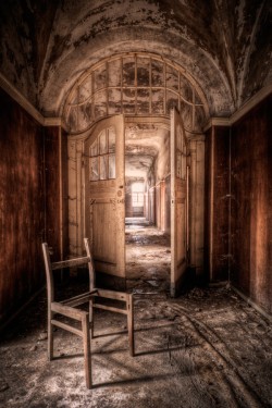 Photograph of a wealthy abandoned house with broken chair in the foreground, for Memory Palace by Malin James